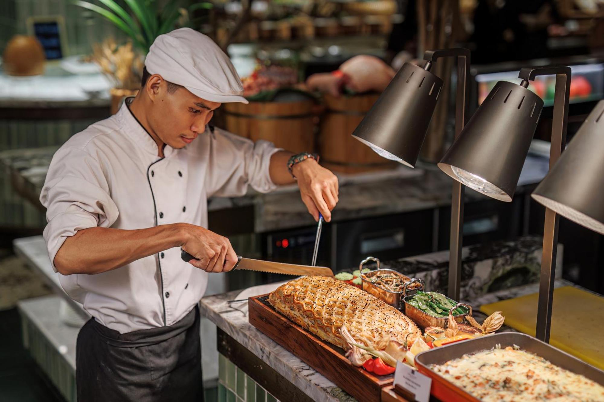 Mai House Saigon Hotel Ho Si Minh-város Kültér fotó A chef carving a roast